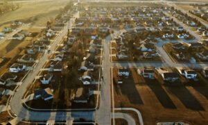 Aerial view of a residential subdivision illustrating subdivision surveys with clearly divided lots, roads, and houses for land development planning.