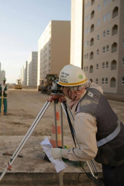 Subdivision surveyor working construction site - ALTA SURVEY New York Licensed land surveyor conducting a subdivision survey with surveying equipment at a construction site