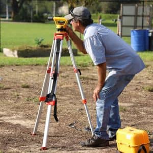 Boundary surveys being performed by a licensed surveyor using professional measuring equipment to verify property lines
