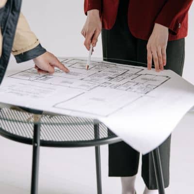 A team reviewing detailed plans during ALTA land title surveys to verify property boundaries and recorded details