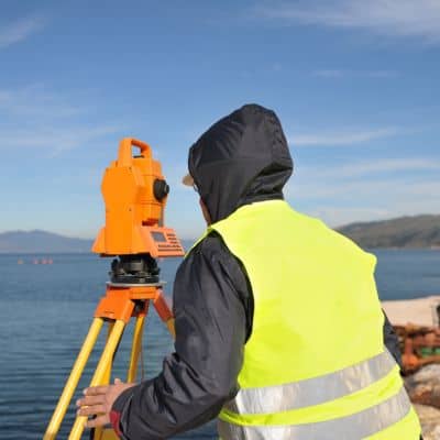 Riverfront site survey equipment - ALTA SURVEY New York Surveyor using precision equipment during a construction survey to establish accurate site control near