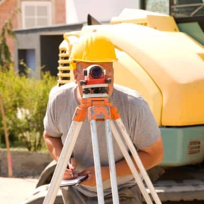 Surveyor using total station field measurement - ALTA SURVEY New York Surveyor using a total station to gather land surveying boundary measurements