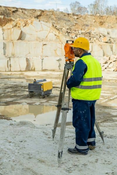 Surveyor total station field - ALTA SURVEY New York Land surveyor using a total station on a property to collect data for a topographic survey