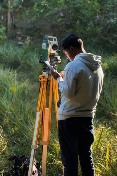 Surveyor checking property boundaries on-site during a due diligence survey