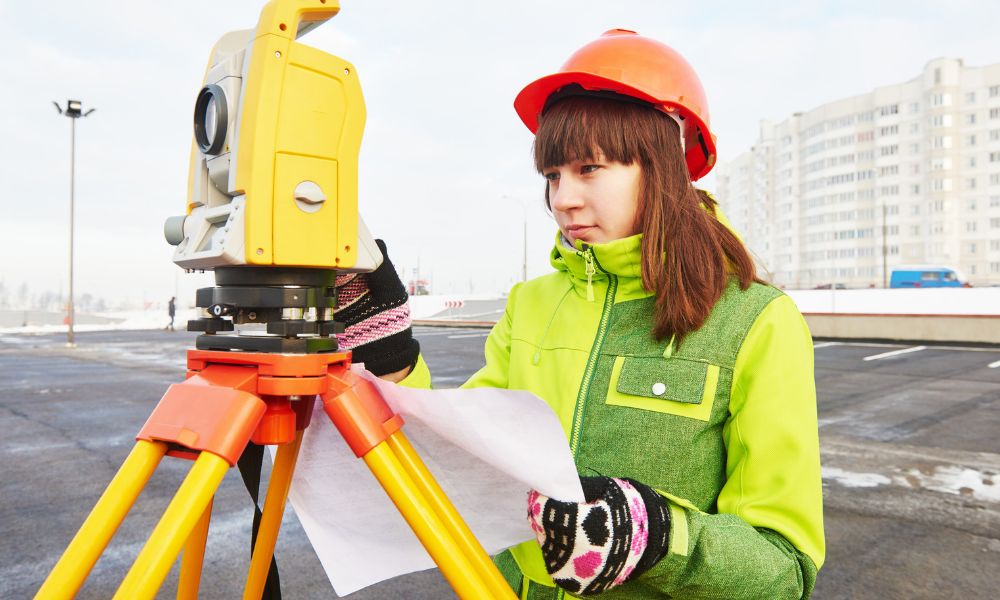 Land surveyor using a total station at a commercial property for a project subject to ALTA survey requirements